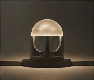Sculptural illuminated dome resting on a dark stone base.